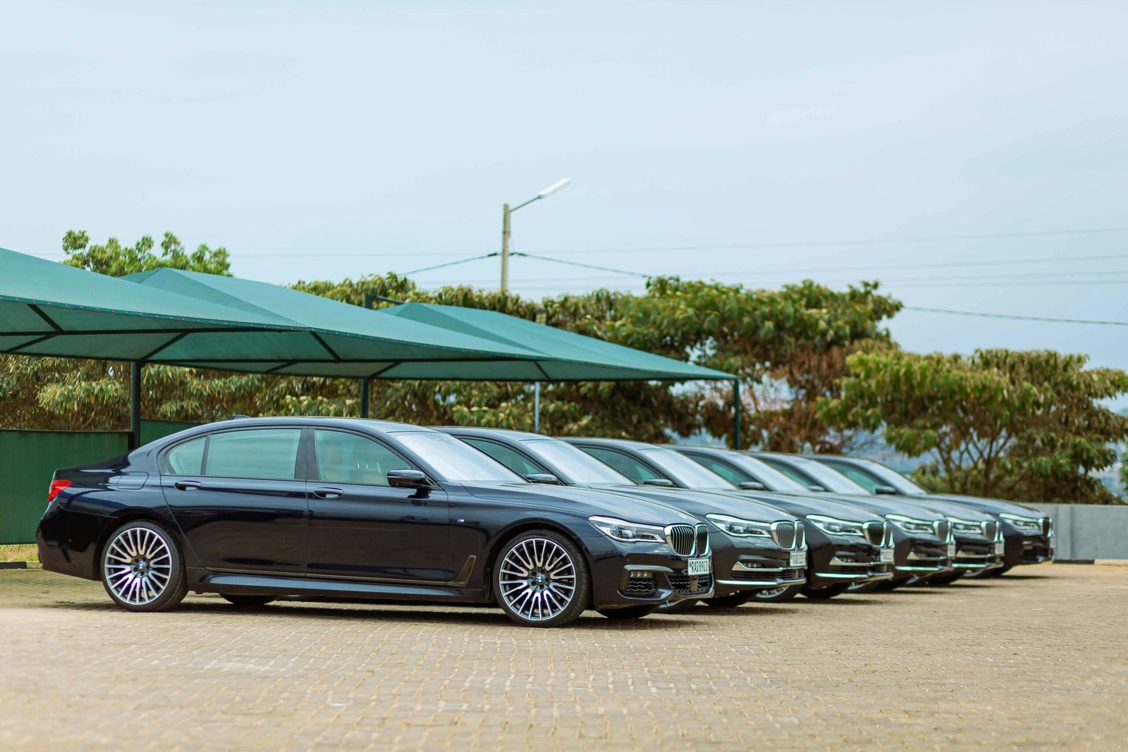 Lineup of luxury BMW Series 7 cars parked outdoors, showcasing elegance and style.